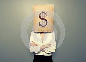 Woman hiding under paper bag with dollar sign