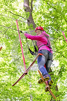 Woman in high rope course or park climbing