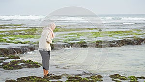 A woman hijab play water in beach, Drini beach, Yogyakarta,