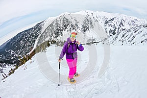 Woman hikeing in the snowy mountains with a phone and snowshoes. and backpack photo