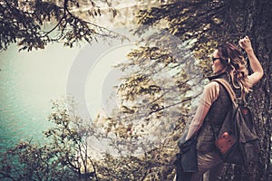 Woman hiker with backpack enjoying amazing mountain lake landscapes.