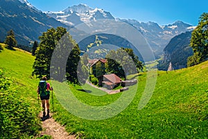 Woman hiker with backpack enjoying the view, Wengen resort, Switzerland