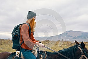 woman hiker with backpack riding horse landscape mountains fresh air