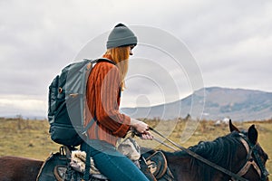 woman hiker with backpack riding horse landscape mountains fresh air