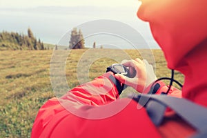 Woman hiker checking the altimeter on sports watch at mountain peak