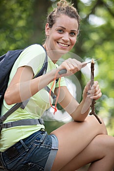 woman hiker cutting pieces wood