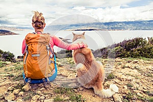 Woman hiker with dog looking at sea