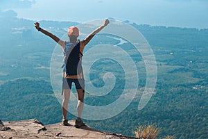 Woman hiker enjoy the view on cliff edge top of mountain