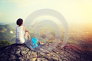 Woman hiker enjoy the view at mountain peak cliff