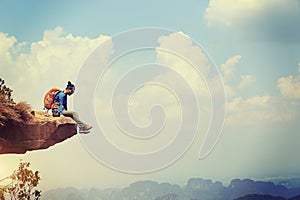 Woman hiker enjoy the view on mountain top cliff