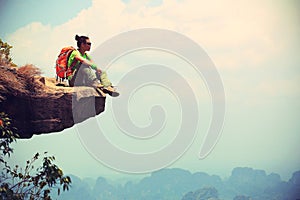 Woman hiker enjoy the view on mountain top cliff