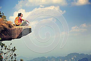 Woman hiker enjoy the view on mountain top cliff