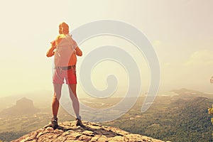 Woman hiker enjoy the view on mountain top rock