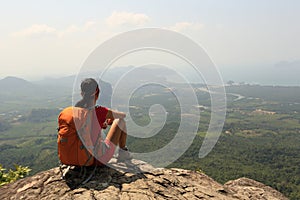 woman hiker enjoy the view on mountain top rock