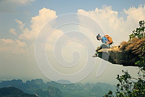 Woman hiker enjoy the view on mountain top rock