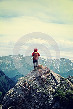 Woman hiker enjoy the view on mountain top rock