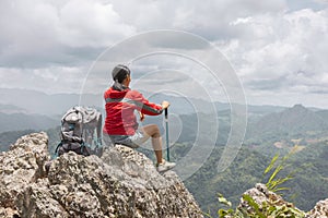 Woman hiker enjoy the view at sunset mountain peak cliff