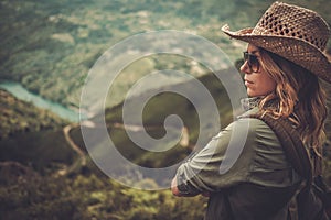 Woman hiker enjoying amazing valley landscapes on a top of mountain.