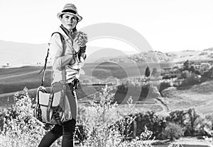Woman hiker enjoying Tuscany view with vintage photo camera
