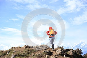 Woman hiker hiking on mountain peak