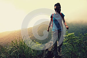 Woman hiker hiking at mountain peak