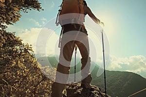 Woman hiker hiking on mountain peak