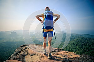 Woman hiker hiking on mountain peak