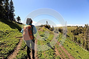 Woman hiker hiking on mountain top trail