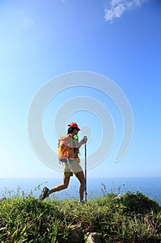 Woman hiker hiking on seaside mountain