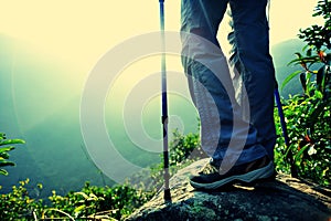 Woman hiker hiking stand on cliff
