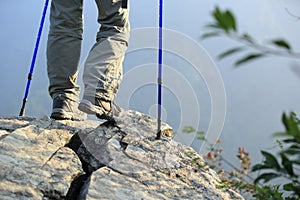 Woman hiker hiking stand on cliff