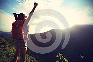 Woman hiker hiking stand on cliff