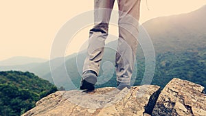 Woman hiker hiking stand on cliff