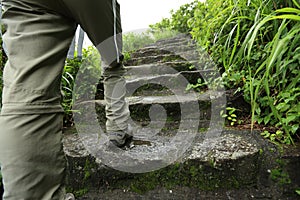 Woman hiker hiking on stone mountain trail