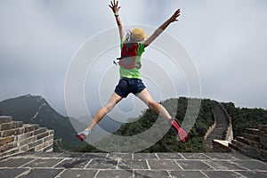 Woman hiker jumping on great wall