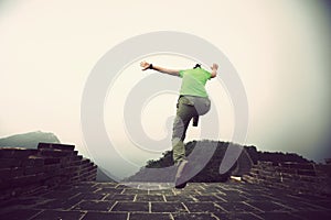 Woman hiker jumping on great wall