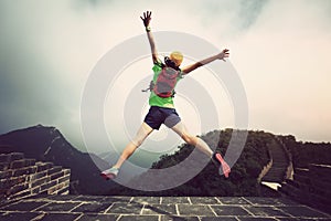 Woman hiker jumping on great wall