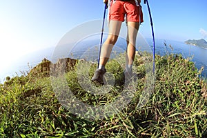 Woman hiker legs hiking on seaside mountain