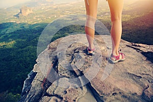 Woman hiker legs on mountain peak rock