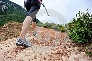 Woman hiker legs walking on seaside mountain trail