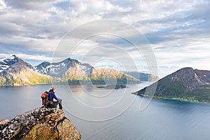 Woman hiker looking at a beautiful Norwegian Fjord landscape