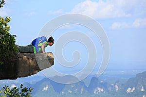 Woman hiker looking down on mountain peak cliff