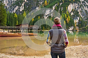 Woman hiker looking out at wooden boats and pier on Lake Bries