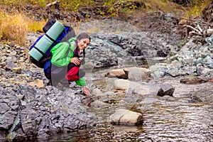 Woman hiker near the mountain stream