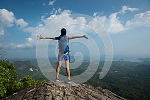 Woman hiker open arms hiking on mountain peak