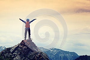 woman hiker open arms on mountainpeak