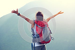 Woman hiker open arms moutain peak photo