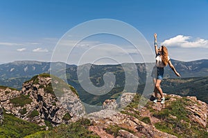 Happy Woman with Hands Up on Mountain Top