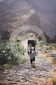 Woman hiker on the picturesque coastal cobbled route. The road joins the towns of Cruzinha, Fontainhas and continues on