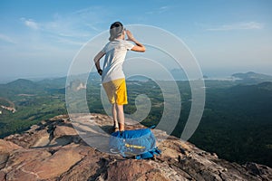 Woman hiker shouting on mountain peak cliff